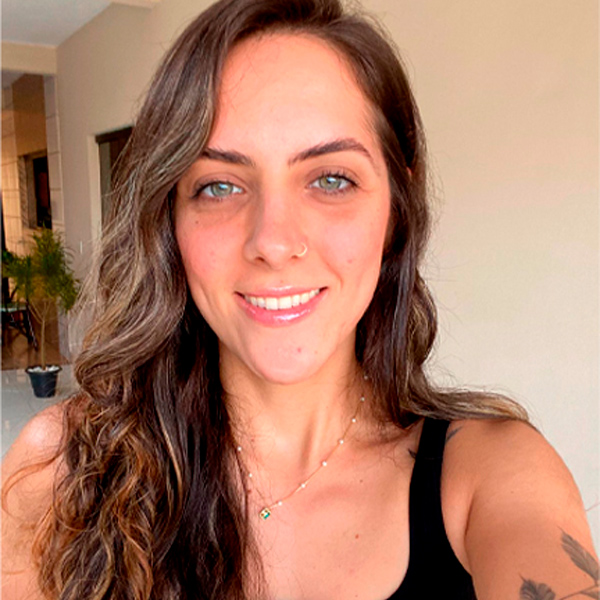 Foto de Bianca Caldeira Araújo, uma mulher de pele clara e cabelos claros ondulados e compridos.