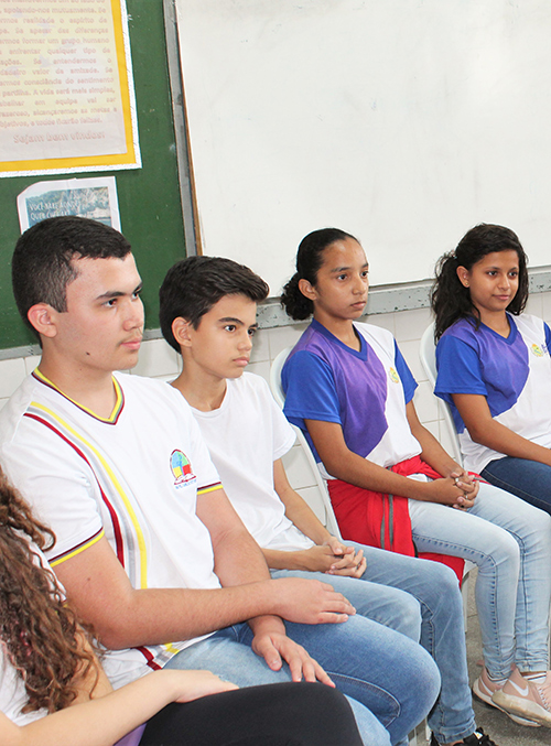 Foto de adolescentes diversos sentados lado a lado em uma roda de conversa